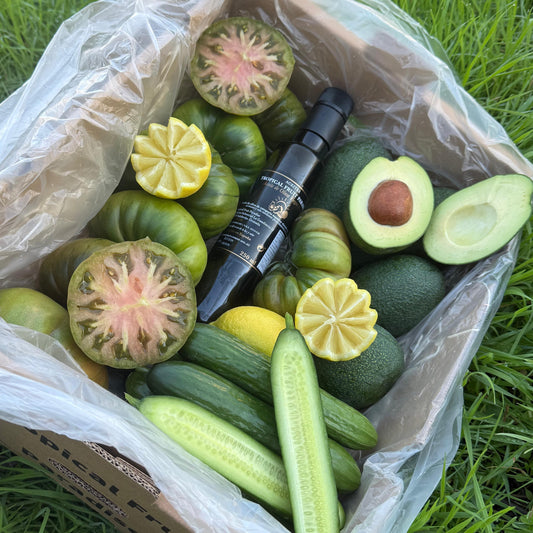 Box of green fruits and vegetables on grass