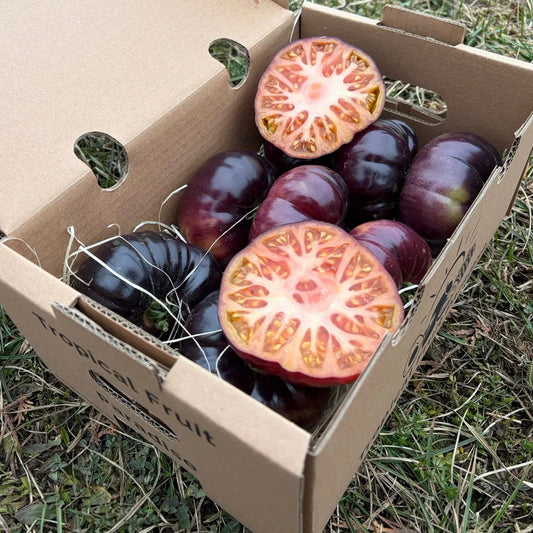 Dark purple Azul heirloom tomatoes, sliced to show beautiful pink-red interior, fresh gourmet delivery box by Tropical Fruit Paradise.