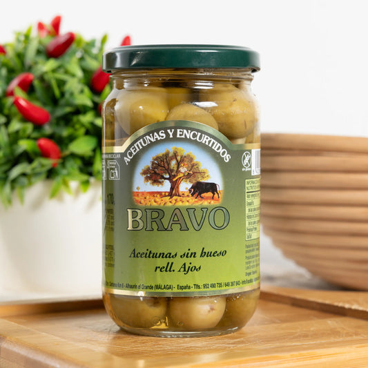Bravo pitted green olives stuffed with garlic cloves in a 170 g glass jar, garlic visible in each olive