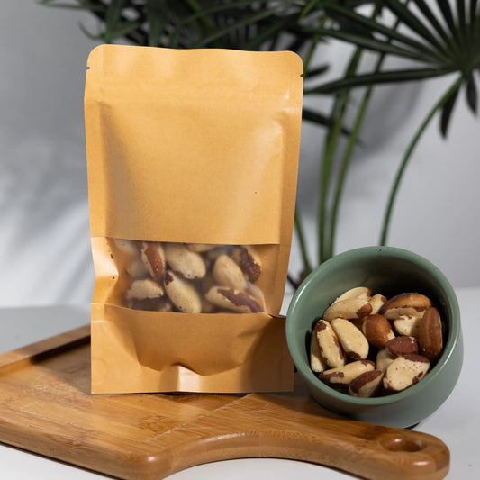 Shelled Brazil nuts in a 100 g kraft pouch and a bowl, long
cream-coloured kernels with brown edges