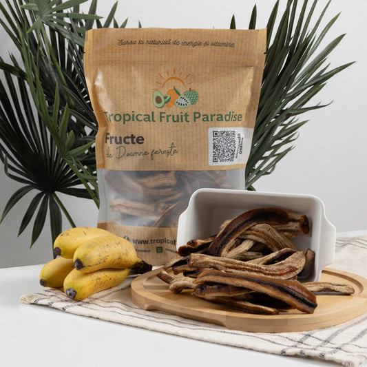 BIO dehydrated banana halves in a Tropical Fruit Paradise kraft pouch, long chewy strips beside fresh baby bananas