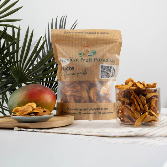 BIO dehydrated mango slices in a Tropical Fruit Paradise kraft pouch, deep amber pieces beside a whole fresh mango