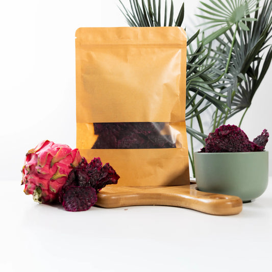 Dehydrated red dragon fruit slices in a kraft pouch and a bowl,
deep magenta pieces flecked with black seeds