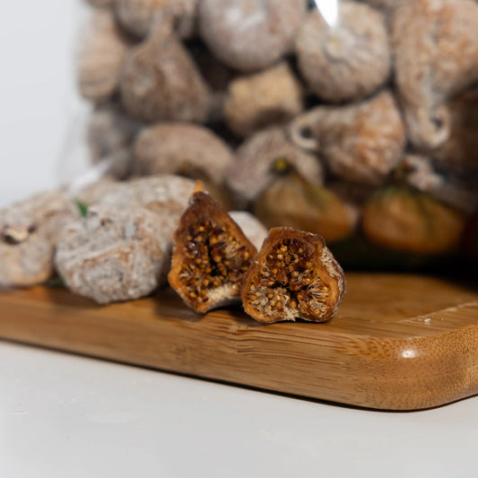Dried fig split open, dense amber flesh packed with golden seeds
under a bloomed skin