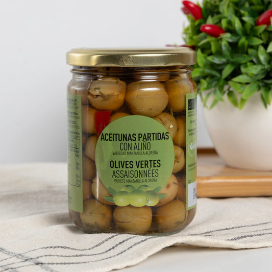 BIO cracked green Manzanilla Aloreña olives in a 250 g glass jar with garlic, thyme and red pepper in the brine