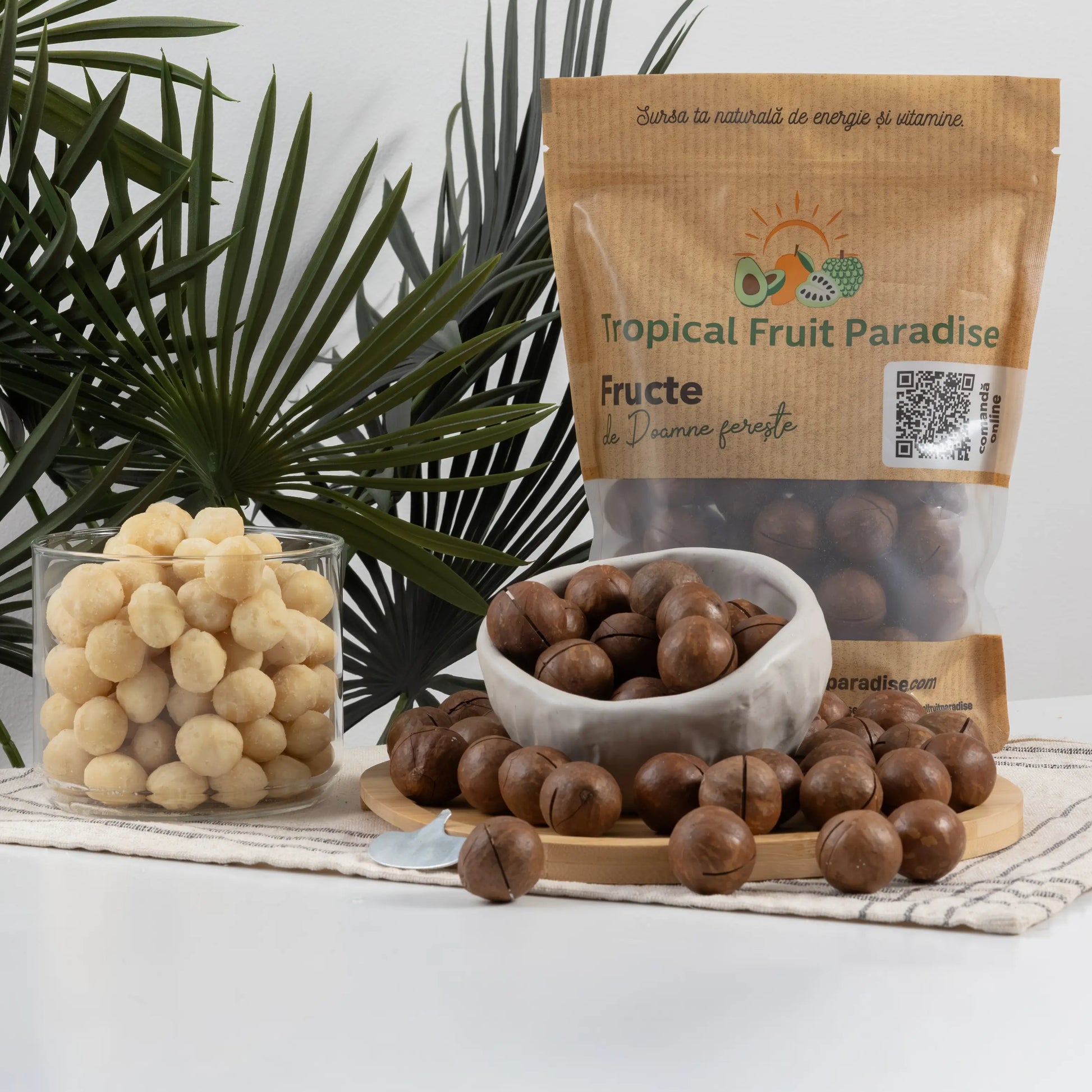 In-shell macadamia nuts in a 500 g Tropical Fruit Paradise kraft pouch, round brown shells scored with a slot for the opening key