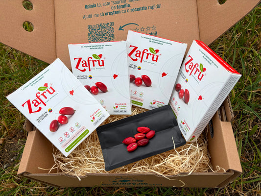 Zafru miracle berry (baya milagrosa) boxes with freeze-dried red berries displayed on an open black sachet, inside a cardboard delivery box on grass.